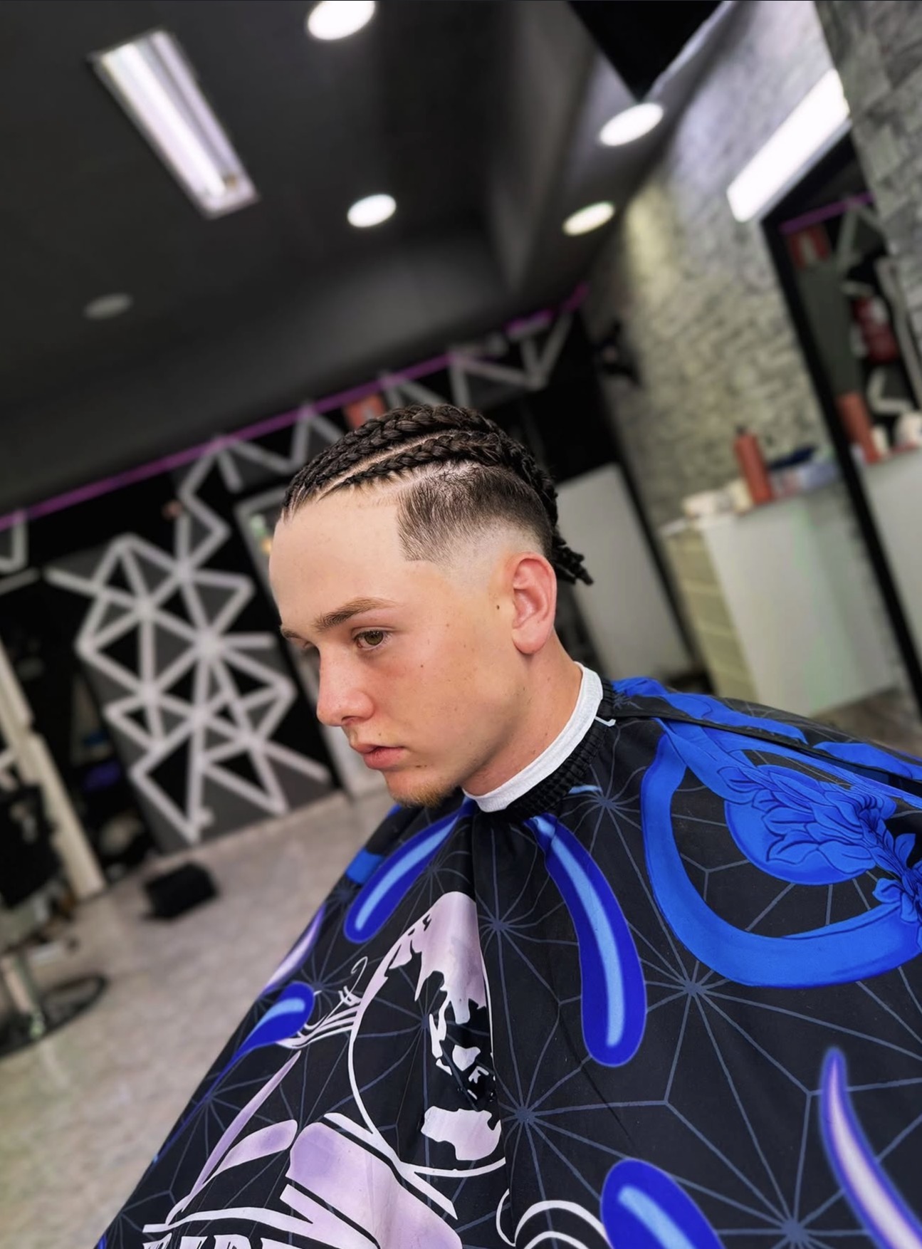 Cliente con corte fade y trenzas en JM Barber Shop